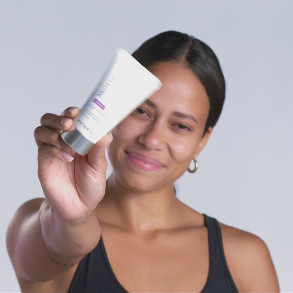 Mains tenant le tube ouvert Neostrata Glycolic Microdermabrasion Polish 75 g, crème sur le dos de la main. - novaprapharmacie